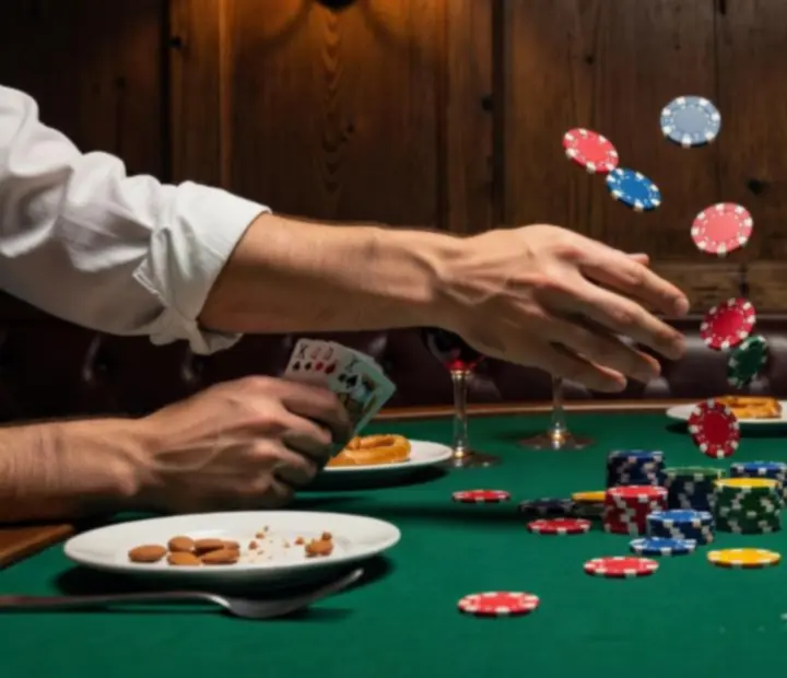 Cozy felt poker table with chips and cards in the lounge.